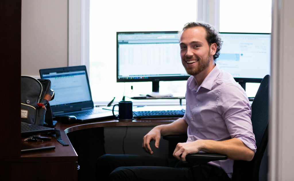 Analyst Smiling at desk